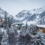 A cozy mountain resort nestled among snow-covered trees and mountains in Almaty, Kazakhstan, during the winter season.