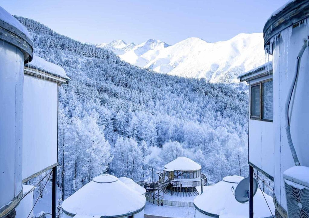 Snowy yurts and winter forest at Mountain View Resort in Alamedin Gorge, Kyrgyzstan.
