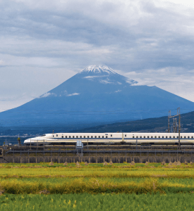 MOUNT FUJI A stunning view of Mount Fuji with a high-speed Shinkansen train passing in the foreground, capturing Japan’s blend of natural beauty and advanced technology.