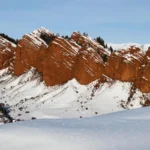 Snow-covered red rock formations of Djety-Oguz Gorge, also known as "Seven Bulls," in Kyrgyzstan.