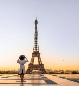 The Effiel Tower Iconic view of the Eiffel Tower in Paris, France, towering over the city with its intricate iron lattice structure, set against a clear blue sky or a glowing sunset backdrop.