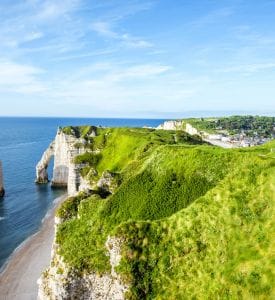 Etretat Scenic view of Étretat, France, showcasing its iconic white chalk cliffs, the natural arch, and the Needle rock formation, with the dramatic coastline meeting the blue waters of the English Channel.