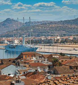 Nafplio Charming view of Nafplio, Greece, with its cobblestone streets, colorful buildings, and the imposing Palamidi Fortress overlooking the town, set against the backdrop of the clear blue waters of the Argolic Gulf.