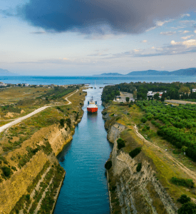 Corinth Canal Aerial view of the Corinth Canal in Greece, showing the narrow waterway that connects the Aegean Sea to the Ionian Sea, surrounded by steep cliffs and lush greenery.